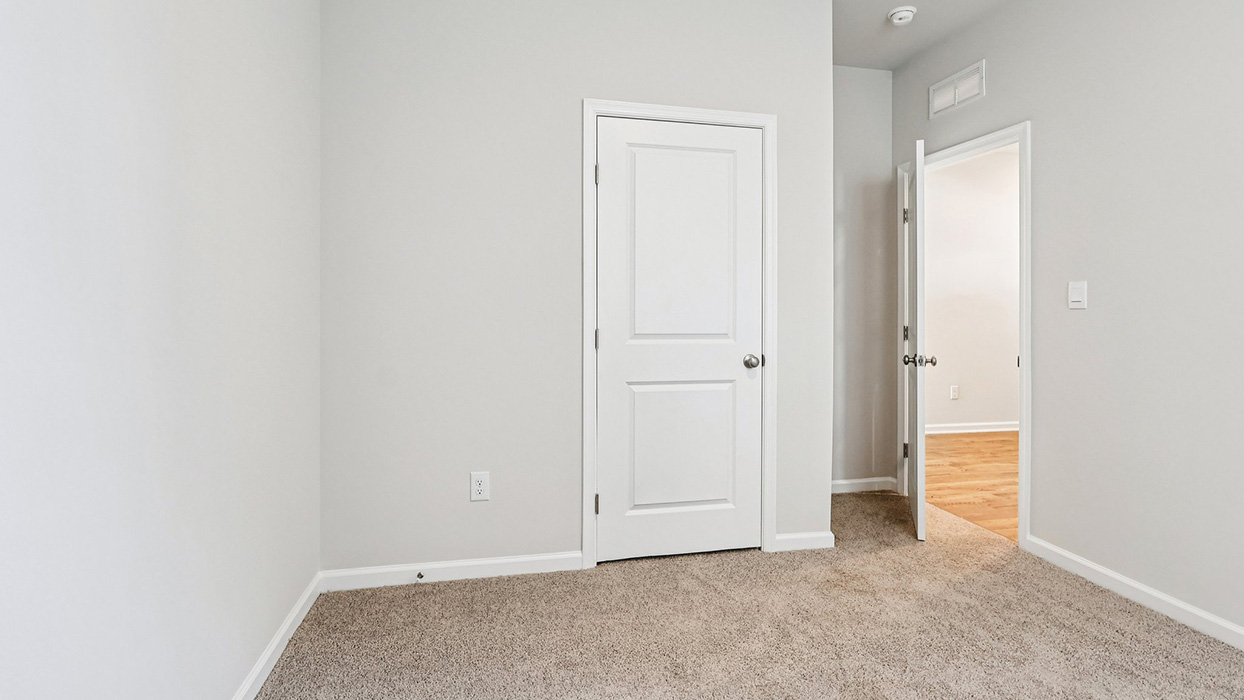 A different view of bedroom three with one closet door
