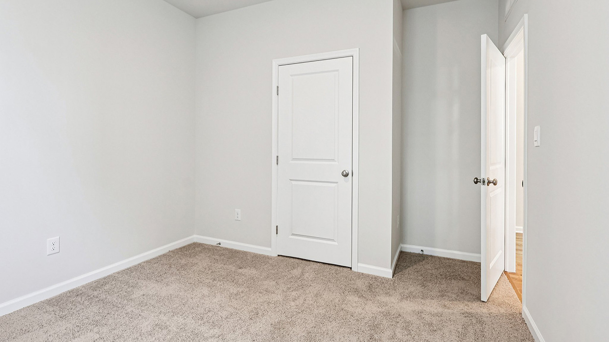 A different view of bedroom three with one closet door