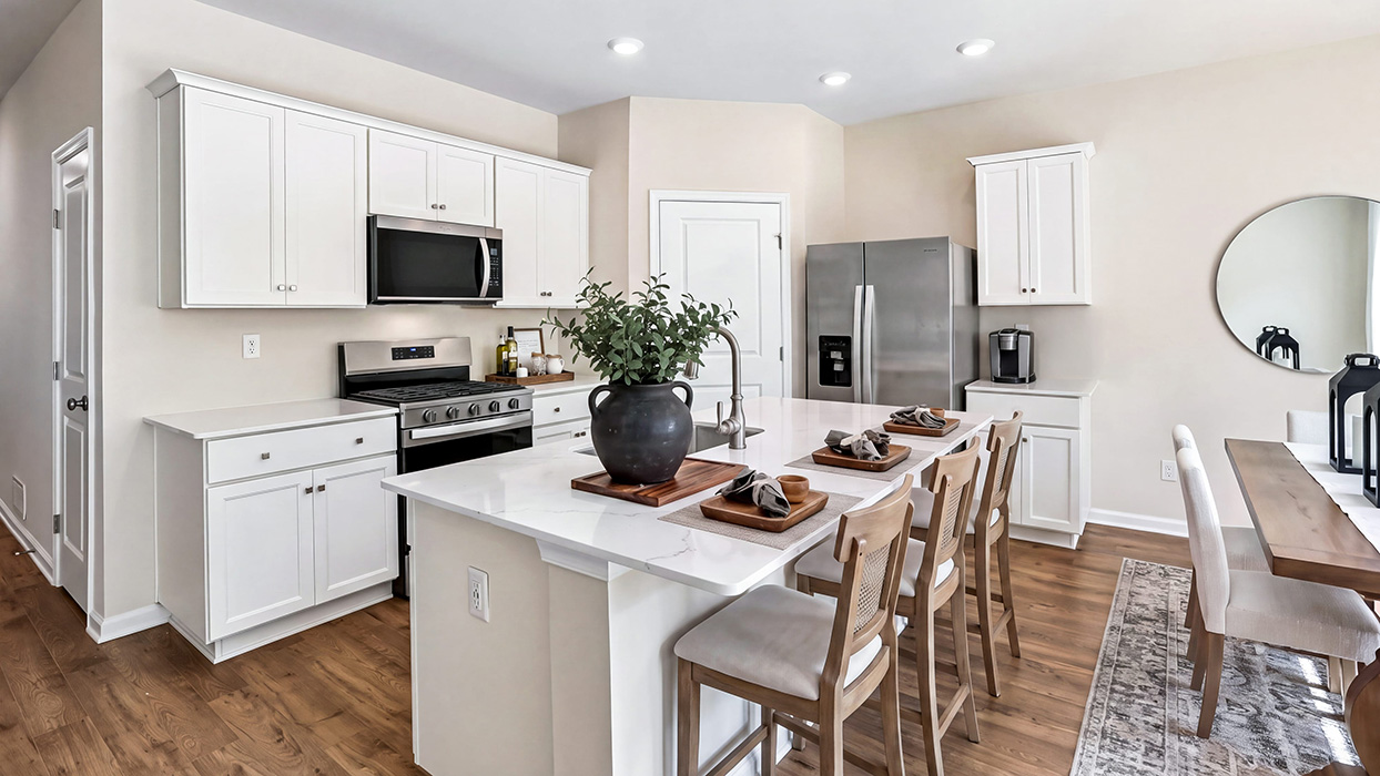 Bright kitchen with island sink, gas range, microwave above, and sliding glass door leading to outdoor space.