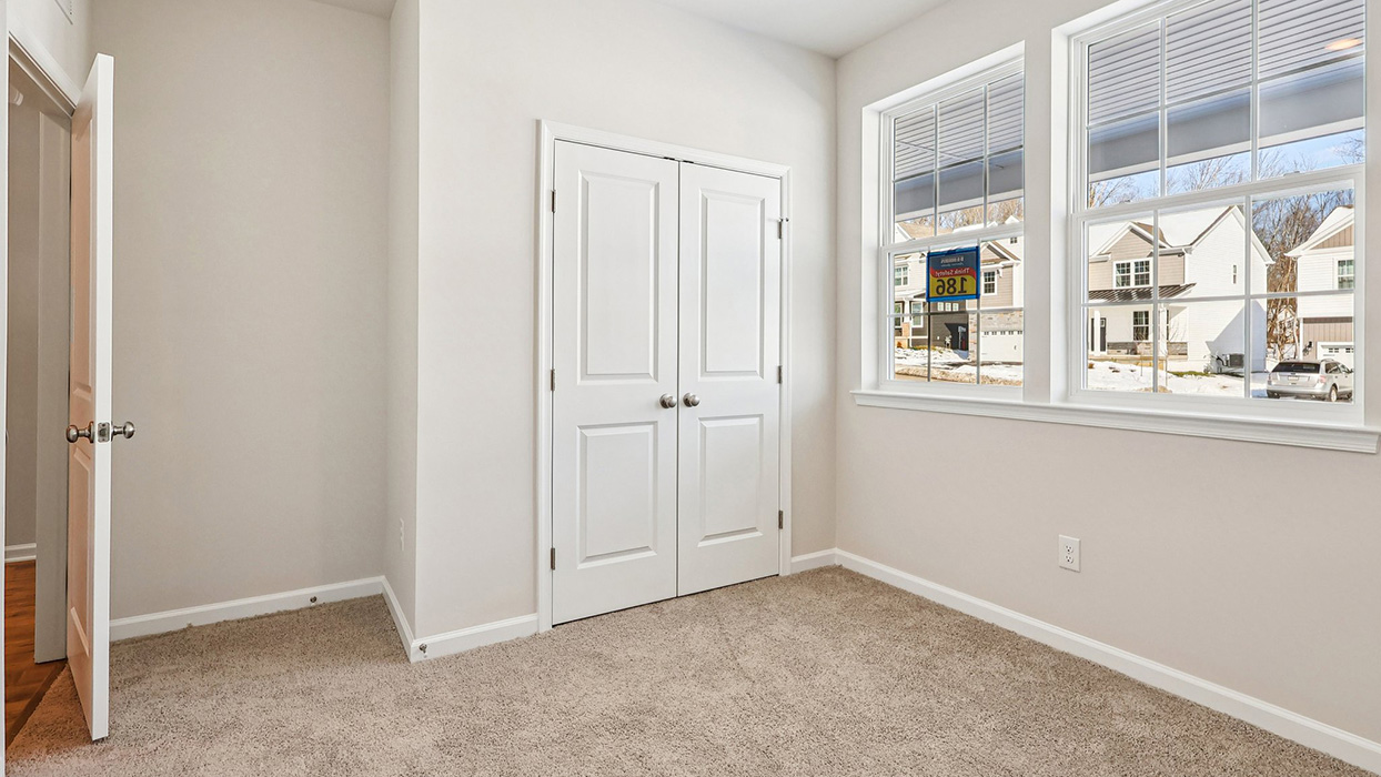 Bedroom two with two windows and double door closet