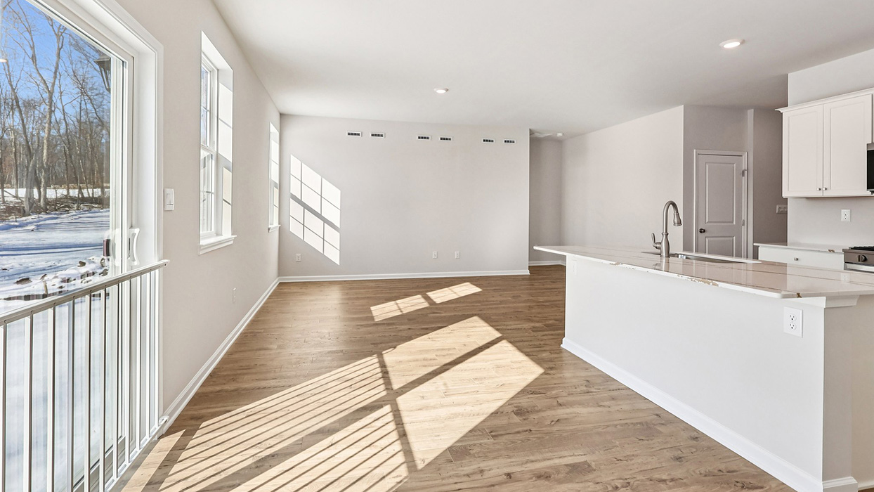 A wide angle view of the living area while looking past the large kitchen island on the right
