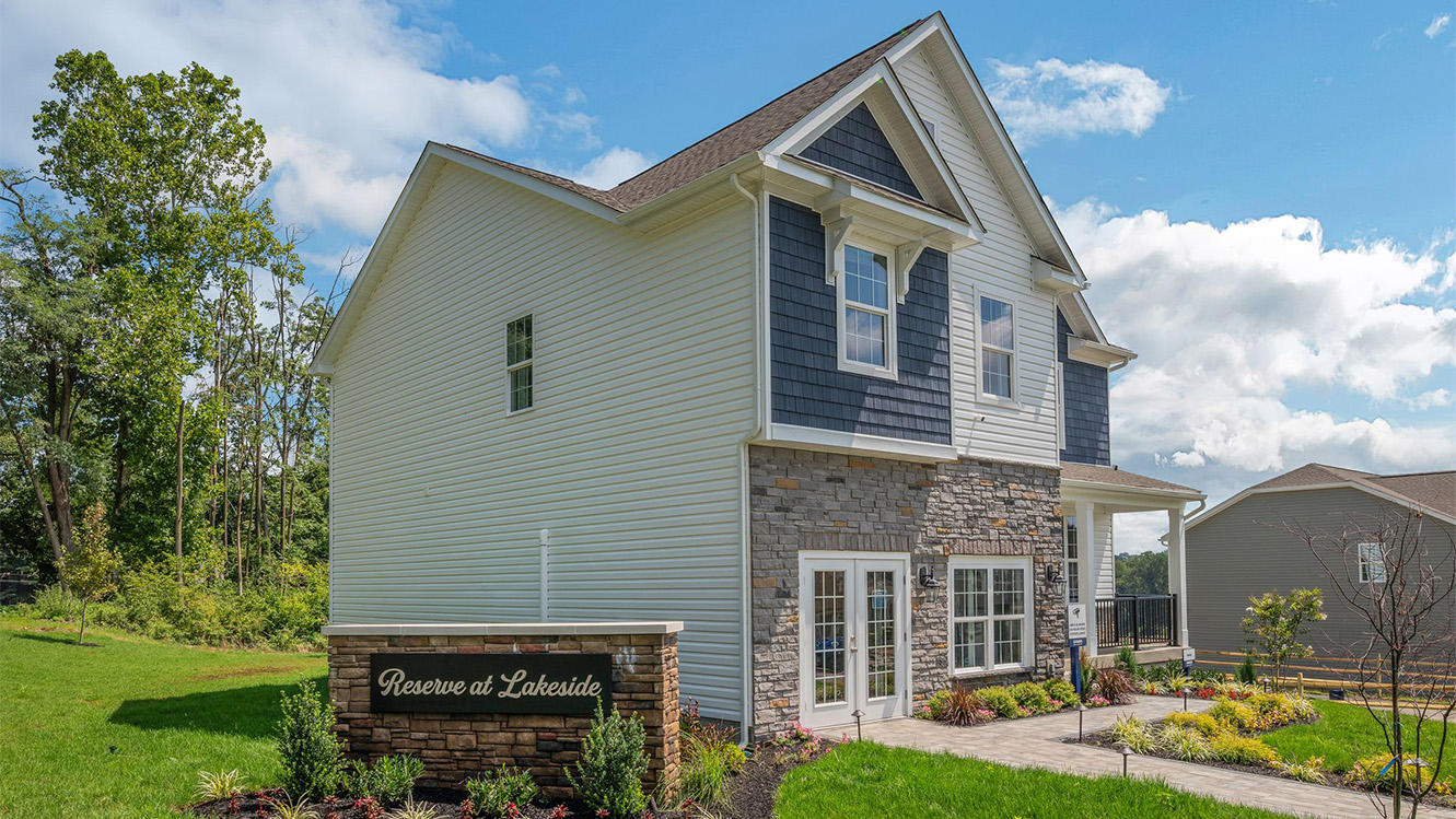 Reserve at Lakeside Henley home with blue and white siding, stone kneewall, light blue front door.