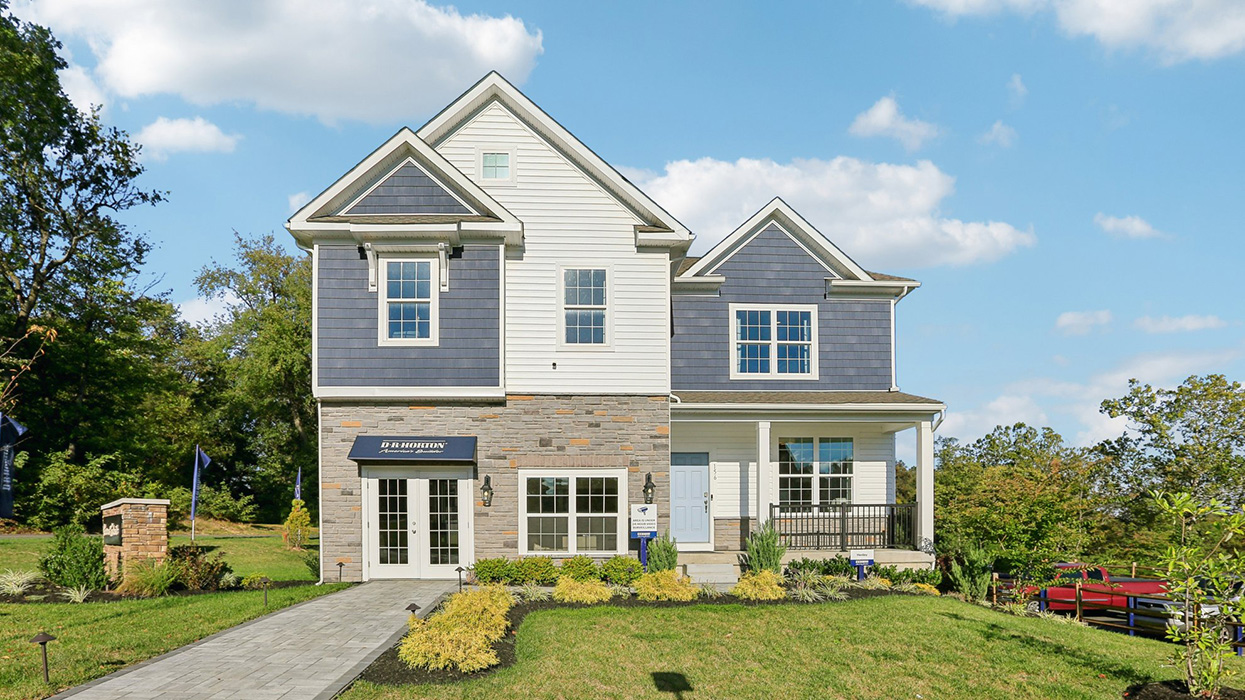 Exterior image of two story home with blue and white siding with brick.
