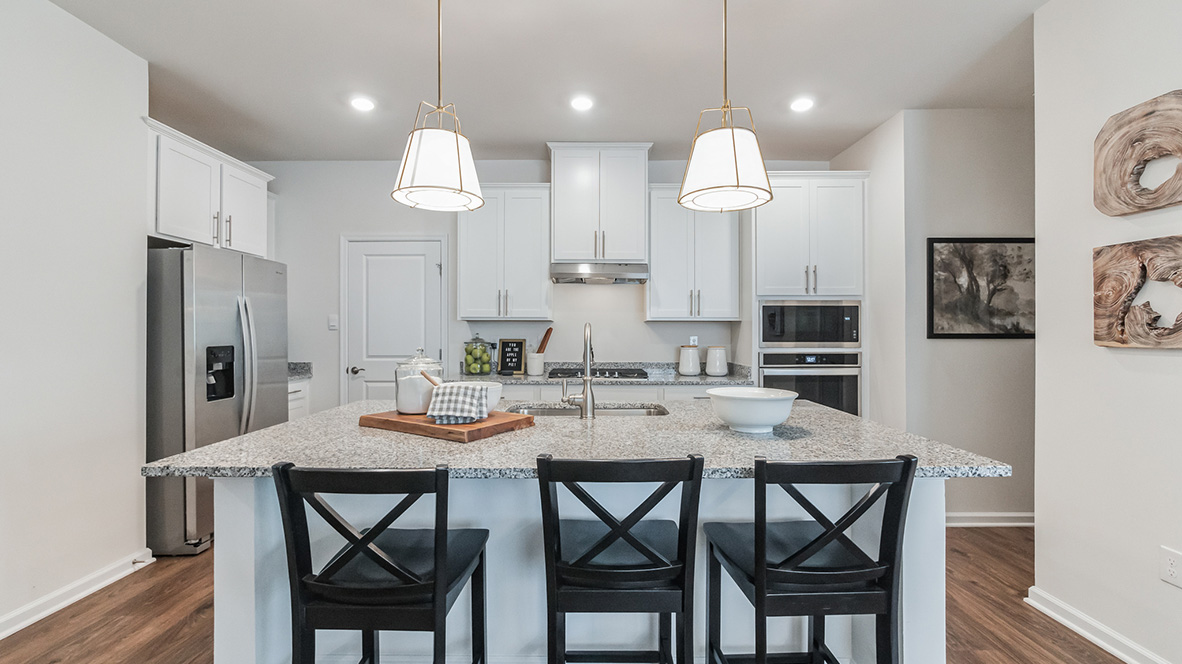 The open-concept kitchen has bright white kitchen cabinets.