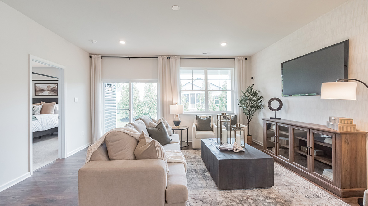 The cozy living area has a double window and laminate plank flooring.