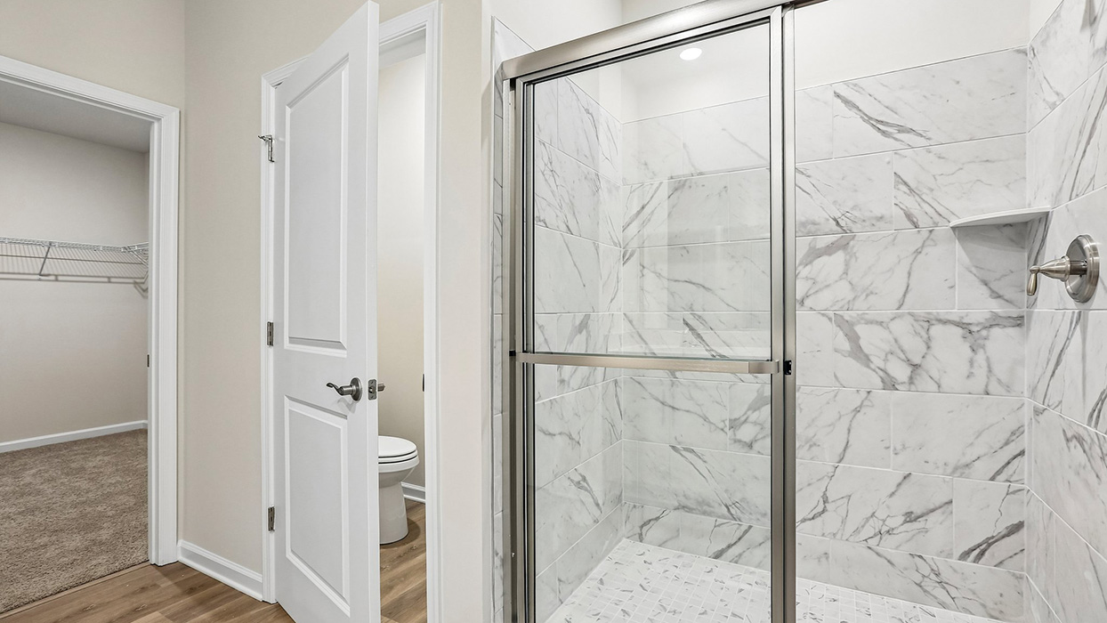 Spacious primary bath with a large walk-in shower and direct access to the primary suite, creating a private owner’s retreat.