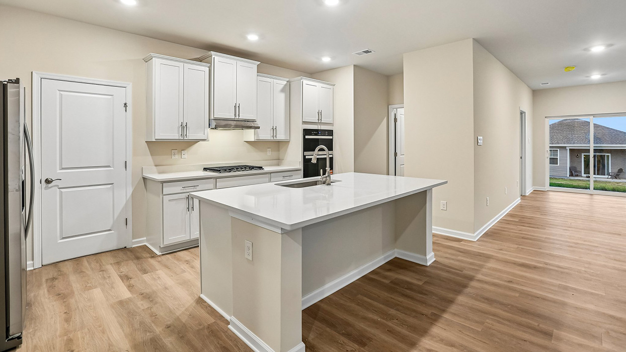 Open-concept kitchen and living area featuring a large center island and seamless flow designed for everyday living, entertaining, and gathering.