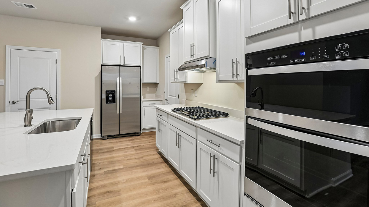Well-appointed kitchen with an oversized island, walkable workspace, and convenient access to dining and gathering areas.