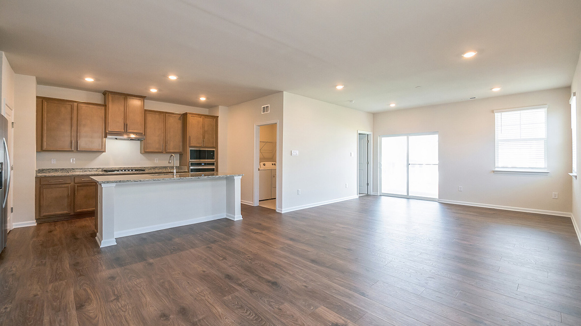 A view into the kitchen area and eat-in island with staineless steel appliances.