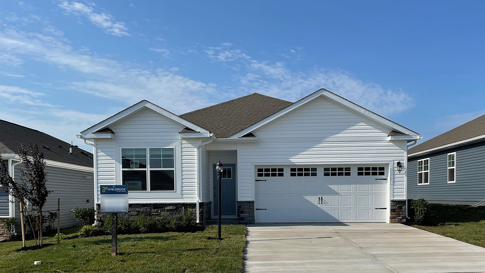 A Merrit home with white siding, white board and batten accent sideing, white trim, and white two car garage
