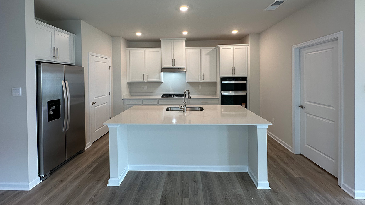The kitchen with white colored cabinets and stainless steel appliances.