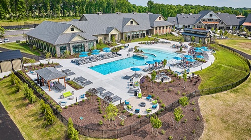 Birds-eye view of the amenity area in Amblebrook with a clubhouse, indoor and outdoor pool, indoor and outdoor pickle ball courts, tennis courts, and a fitness center.