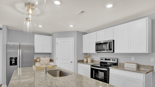 The kitchen with white cabinets.