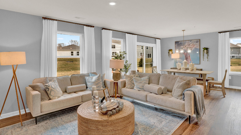 Open-concept living room with spacious layout, multiple windows, and strong natural light throughout