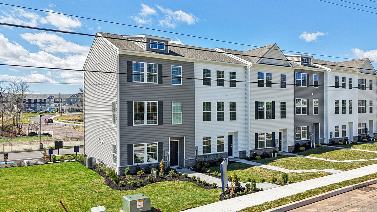 Exterior front image of the model townhome with harvard slate color siding dark gray shutters and a navy front door