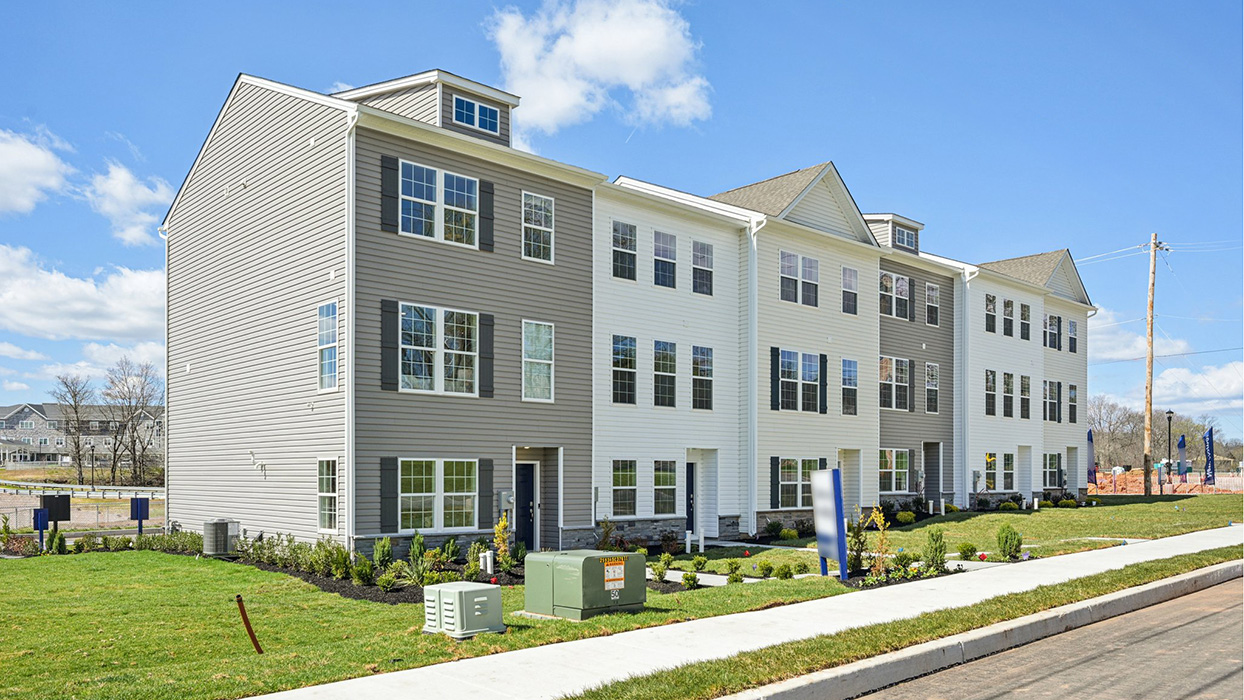 Exterior front image of the model townhome with harvard slate color siding dark gray shutters and a navy front door