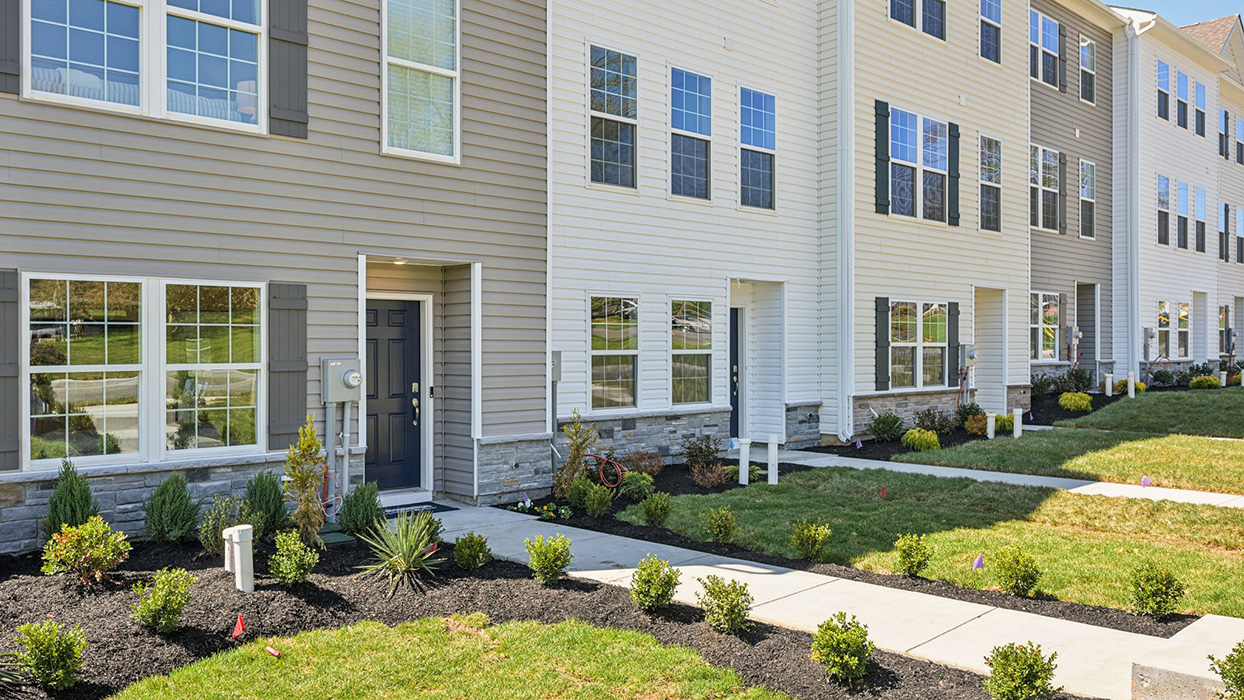 Exterior front image of the model townhome with harvard slate color siding dark gray shutters and a navy front door