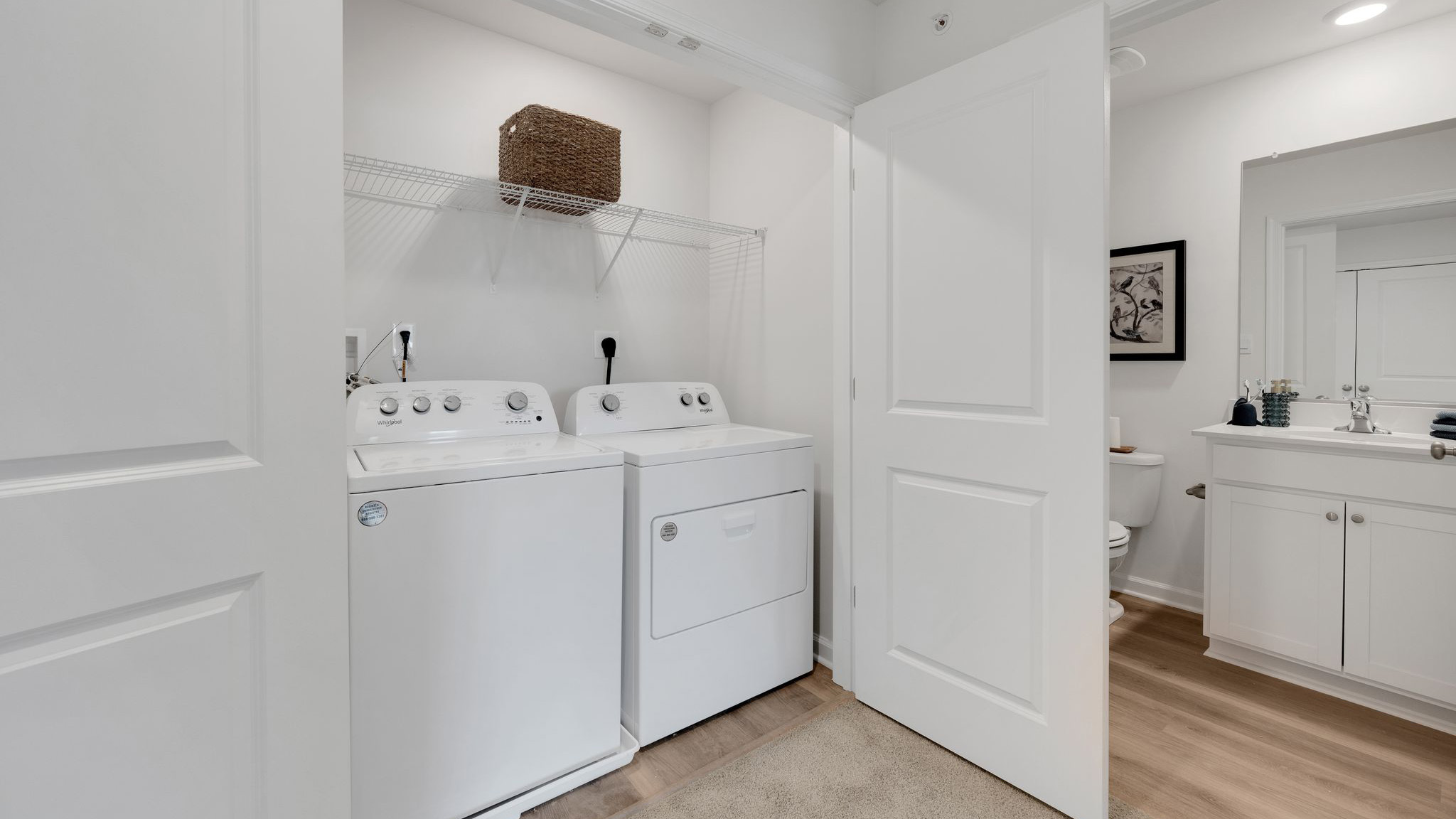 Laundry room with with washer and dryer and shelf above.