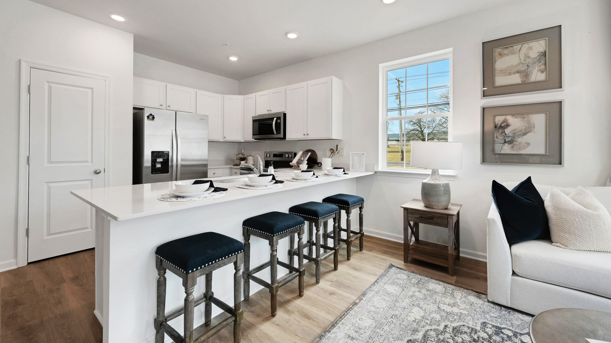 The kitchen area and pantry closet with part of the living area on the right.