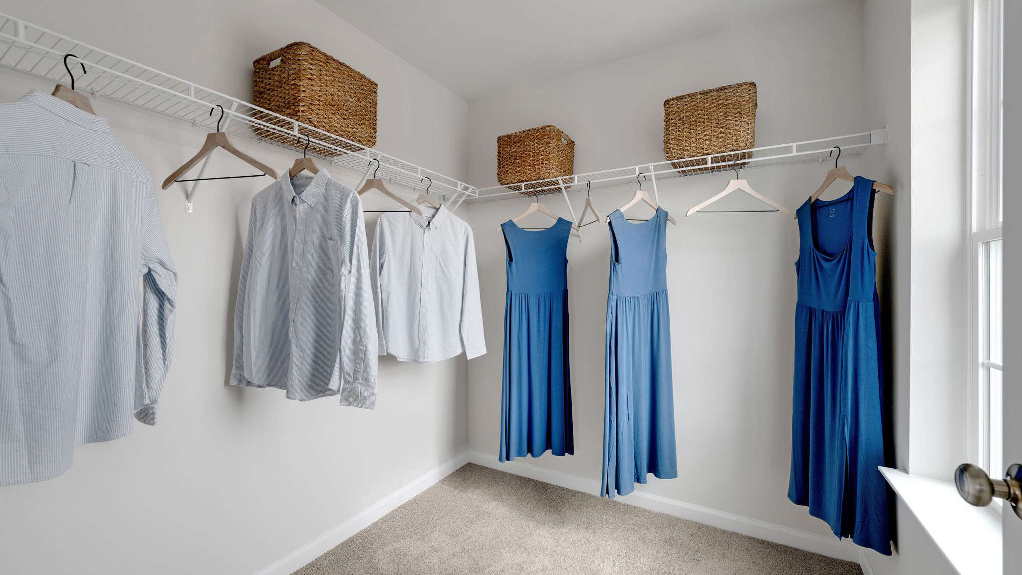 Large closet with shelves and racks and a single window.