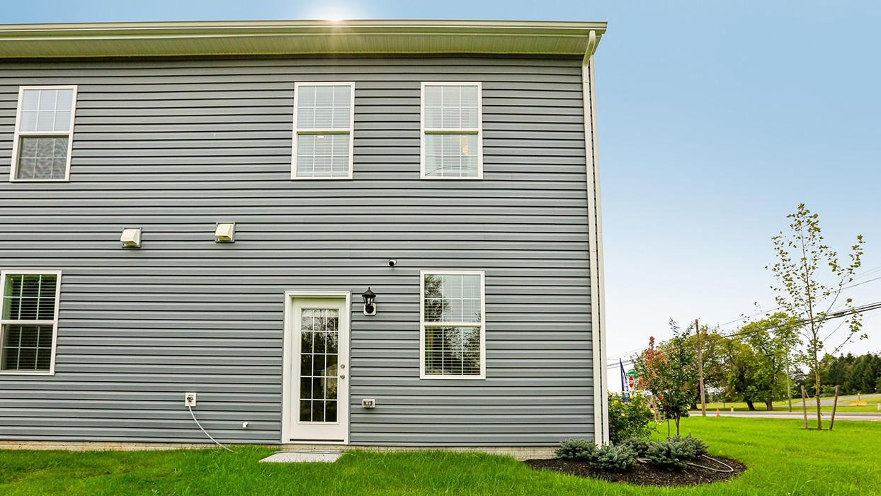Exterior rear image of the model townhome with dark gray horizontal paneling