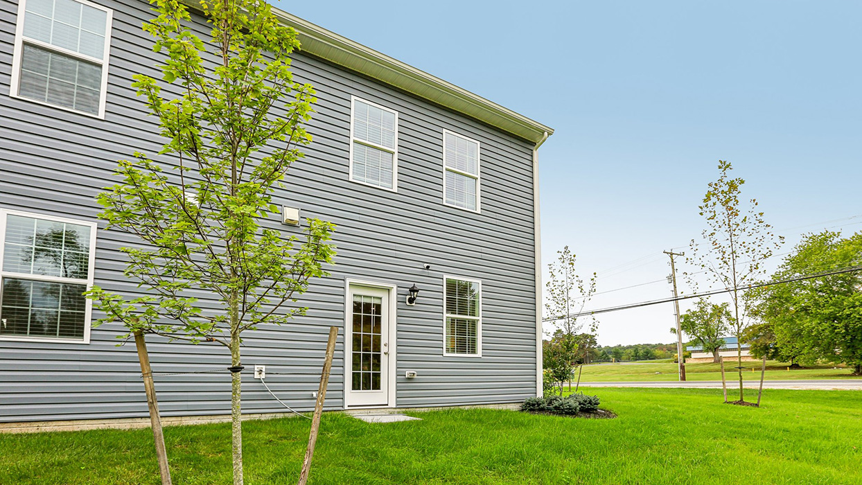 Exterior rear image of the model townhome with dark gray horizontal paneling