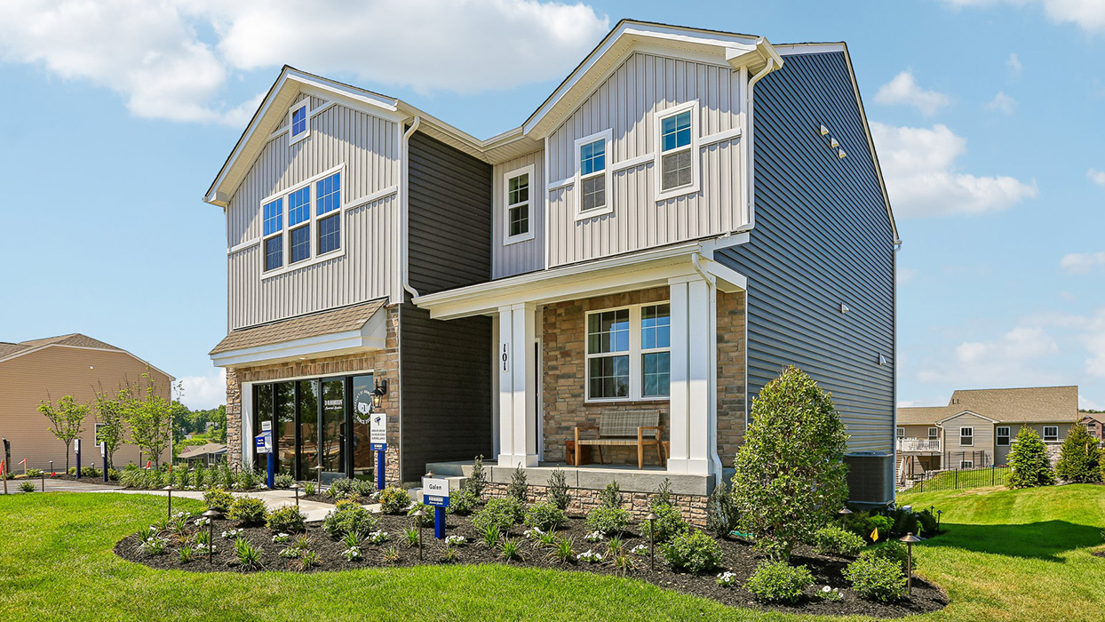A side-angle of a two-story Galen home with ironstone and cream siding, stone siding, and stone front with a front porch.