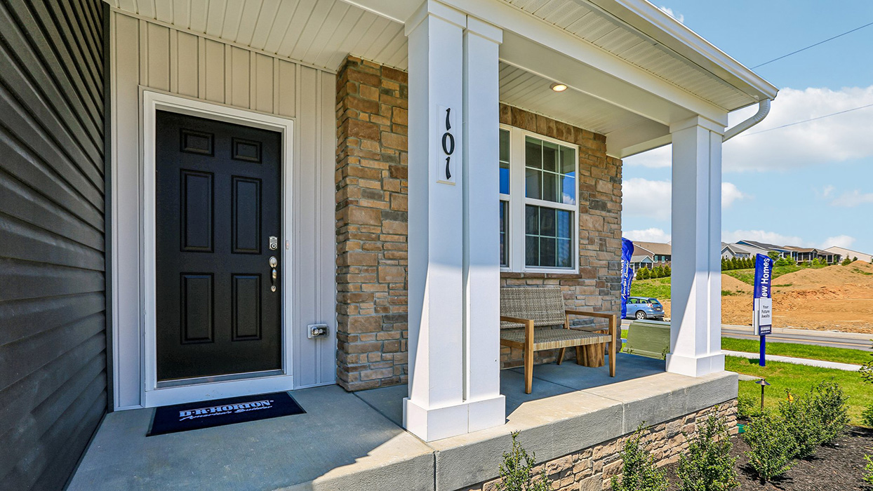 A view of the front door of the Cider Press Station Galen home with stone front and ironstone siding.