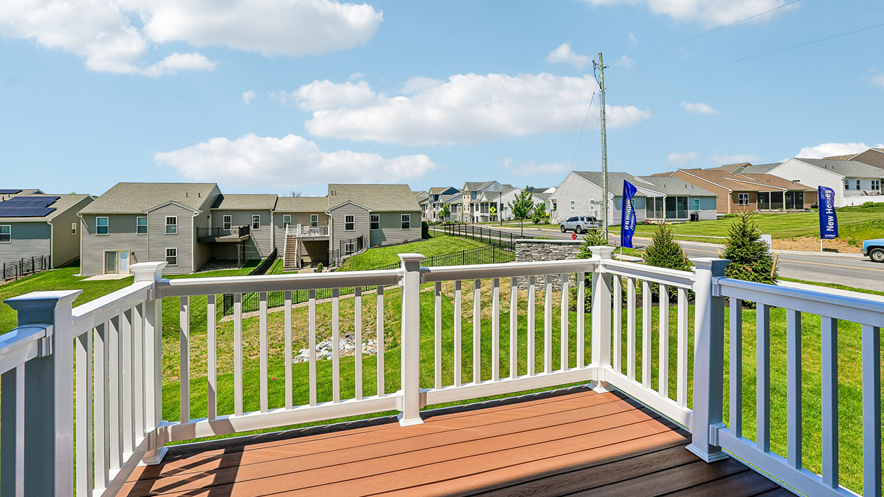 A view of back porch with white fencing.