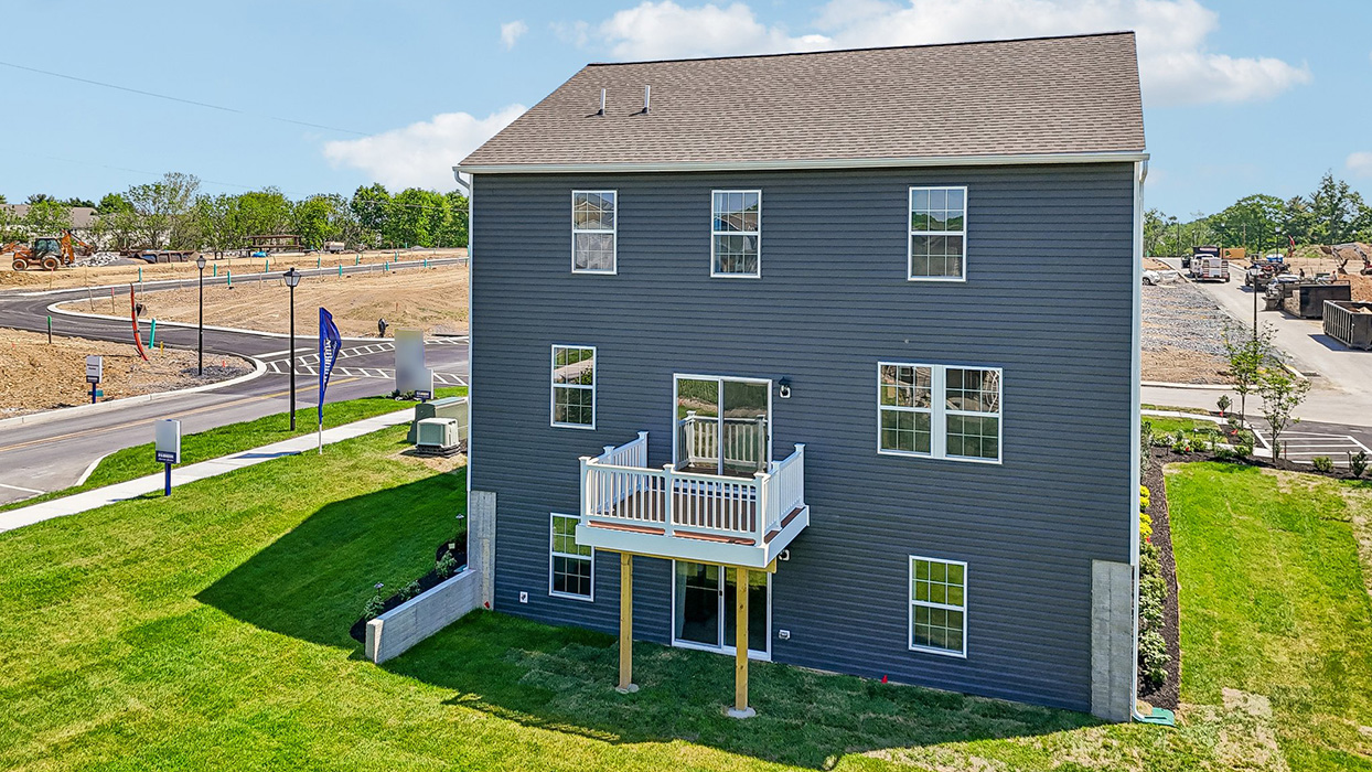 An aerial rear view of a two-story Galen home with ironstone siding, six windows, and walkout basement.