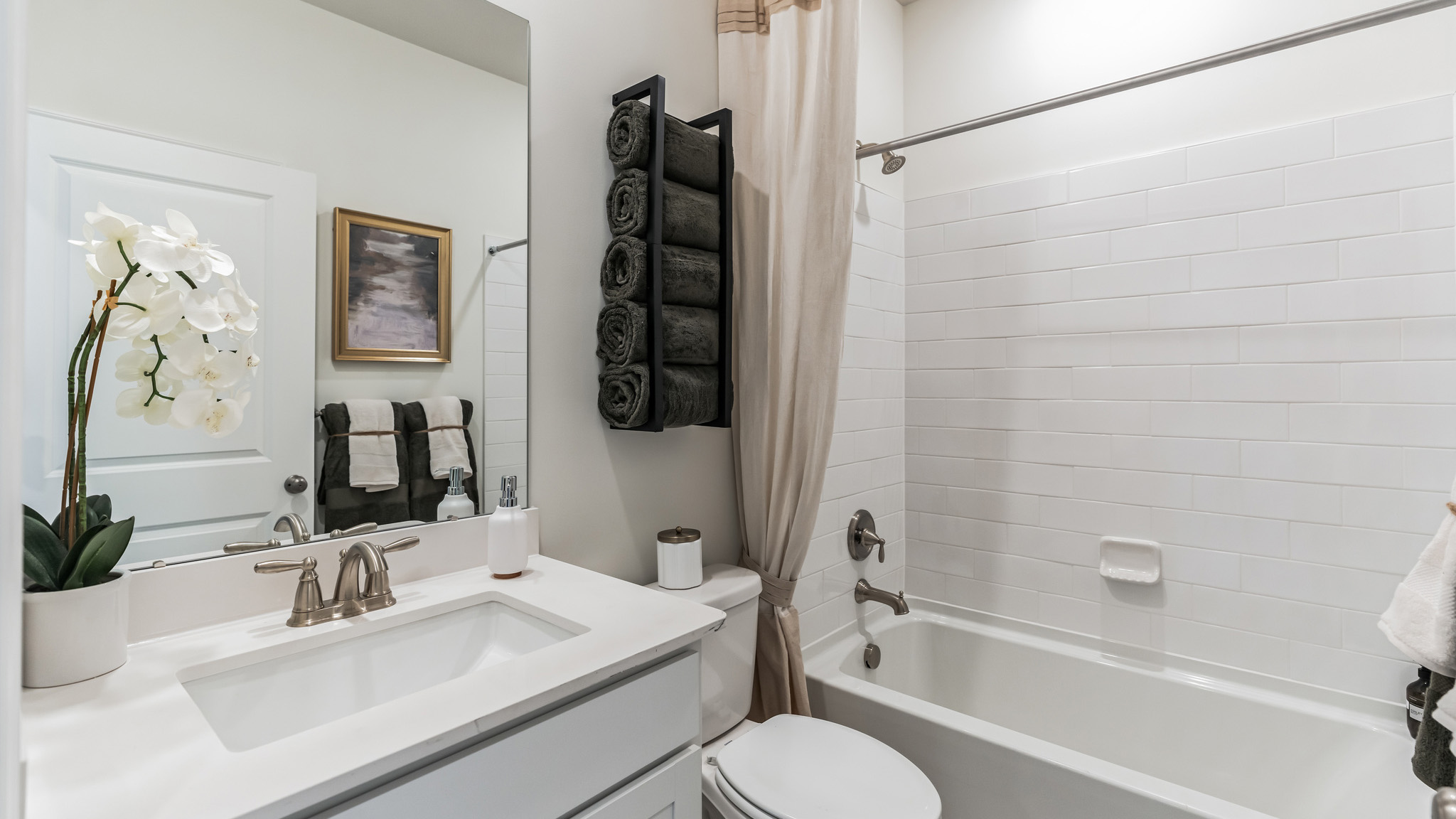 Full bath with single sink white vanity and bathtub.
