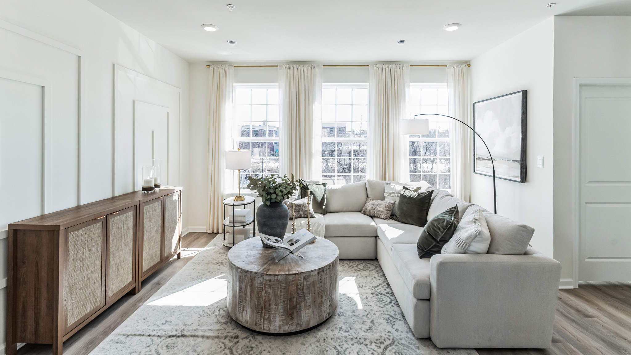 Straight view of the living area with three large windows for plenty of natural light.