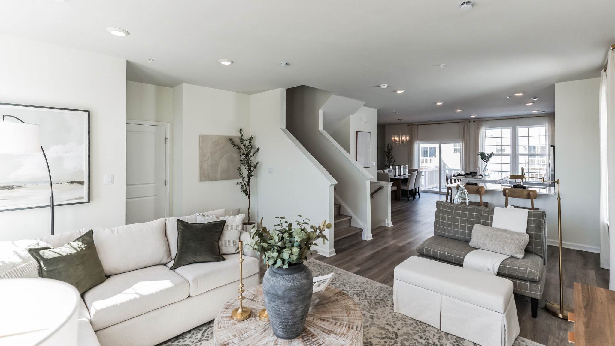 Living area with stairs, kitchen and dining area in the foreground.