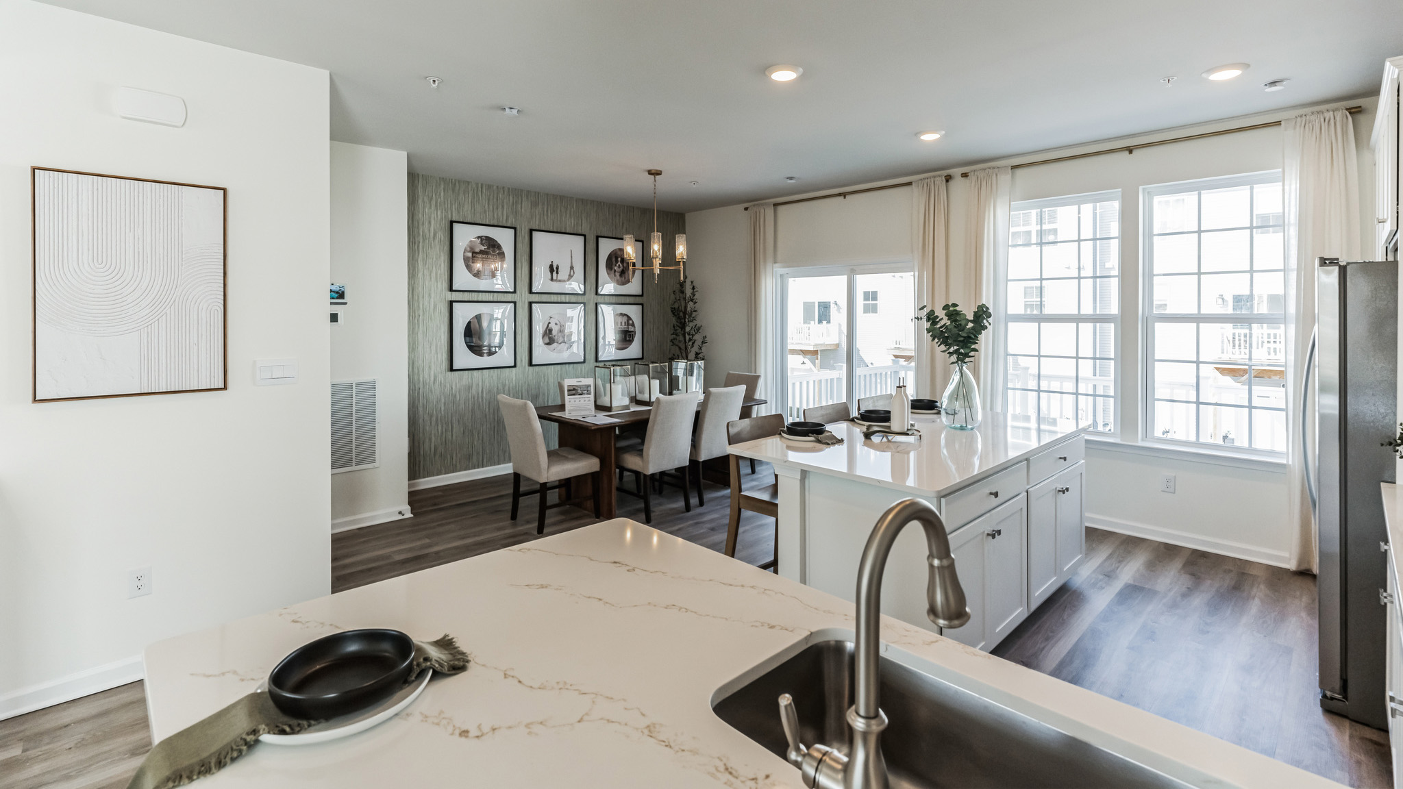 Kitchen area on the second floor flowing into the dining area with the sliding glass door in the back.