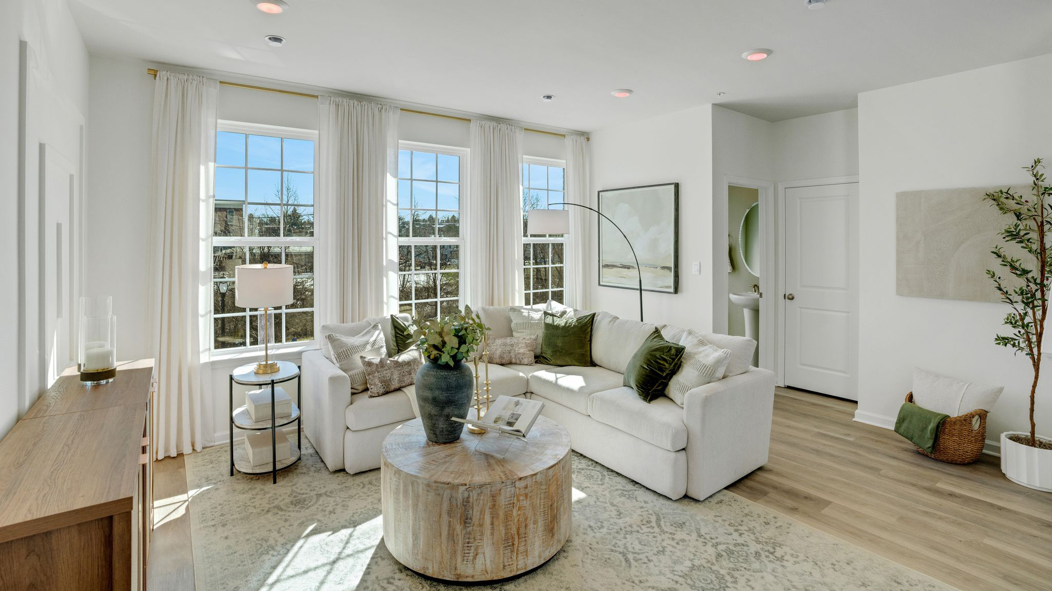 Living area with the three large windows and half bath in the back.