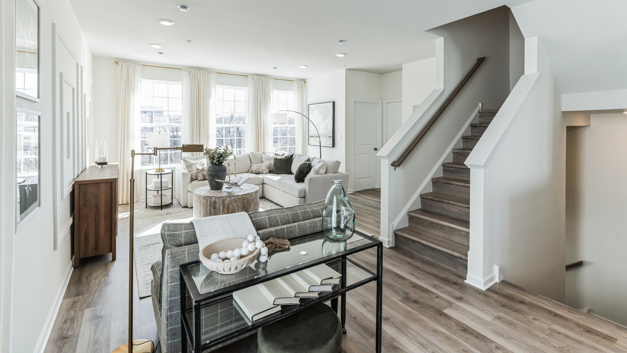 Kitchen area with half bath in the back right corner. View of the stairs to the right.