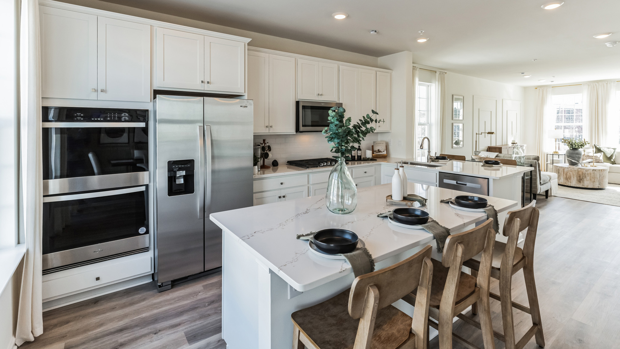 Kitchen area with stainless steel appliances flowing into the living area.