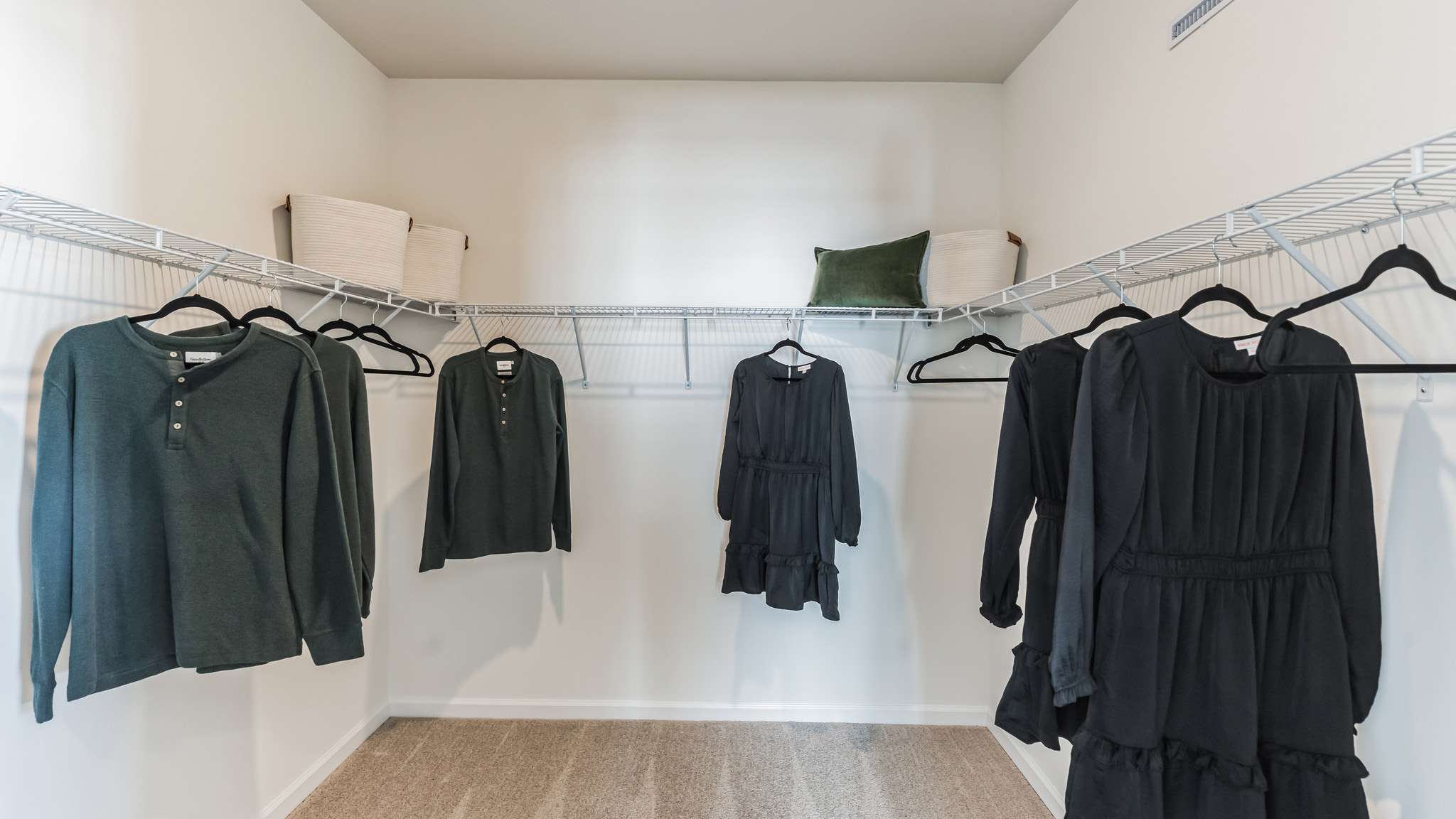 Large connecting closet to the primary bedroom with racks and shelves.