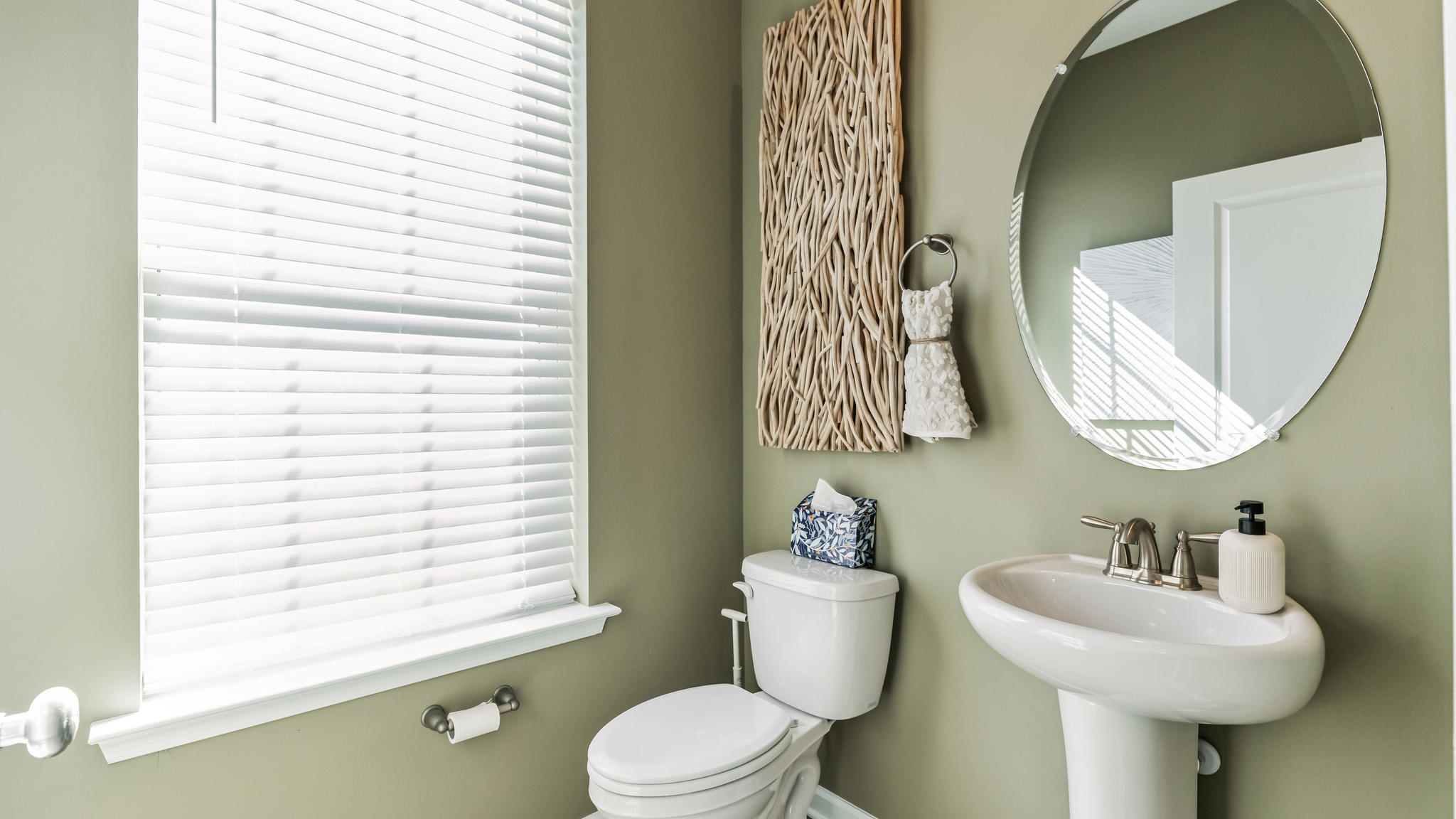 Half bath with single sink that is located off the living area.