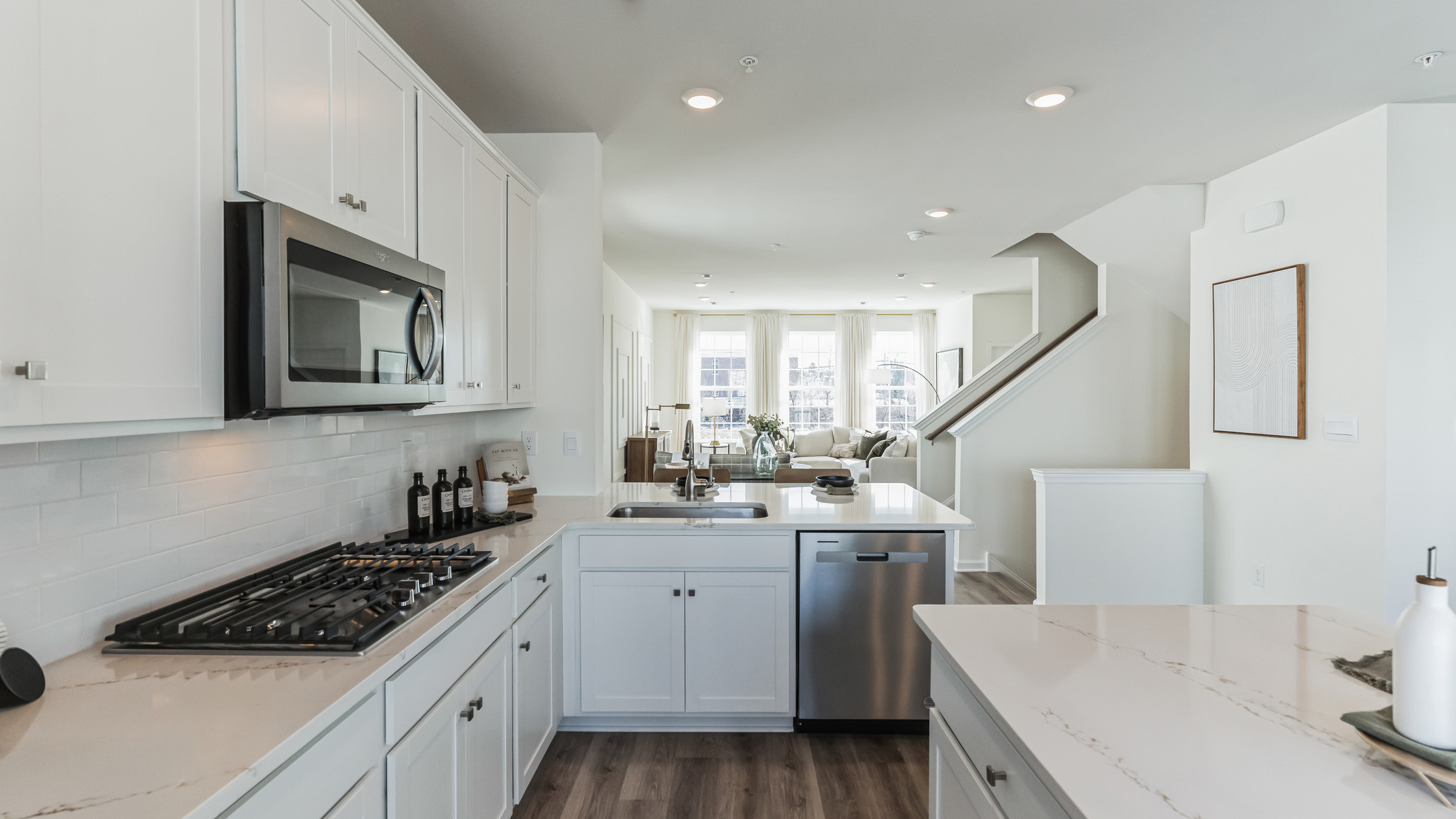 Walkway between the kitchen island and the backside of the kitchen, viewing into the living area.