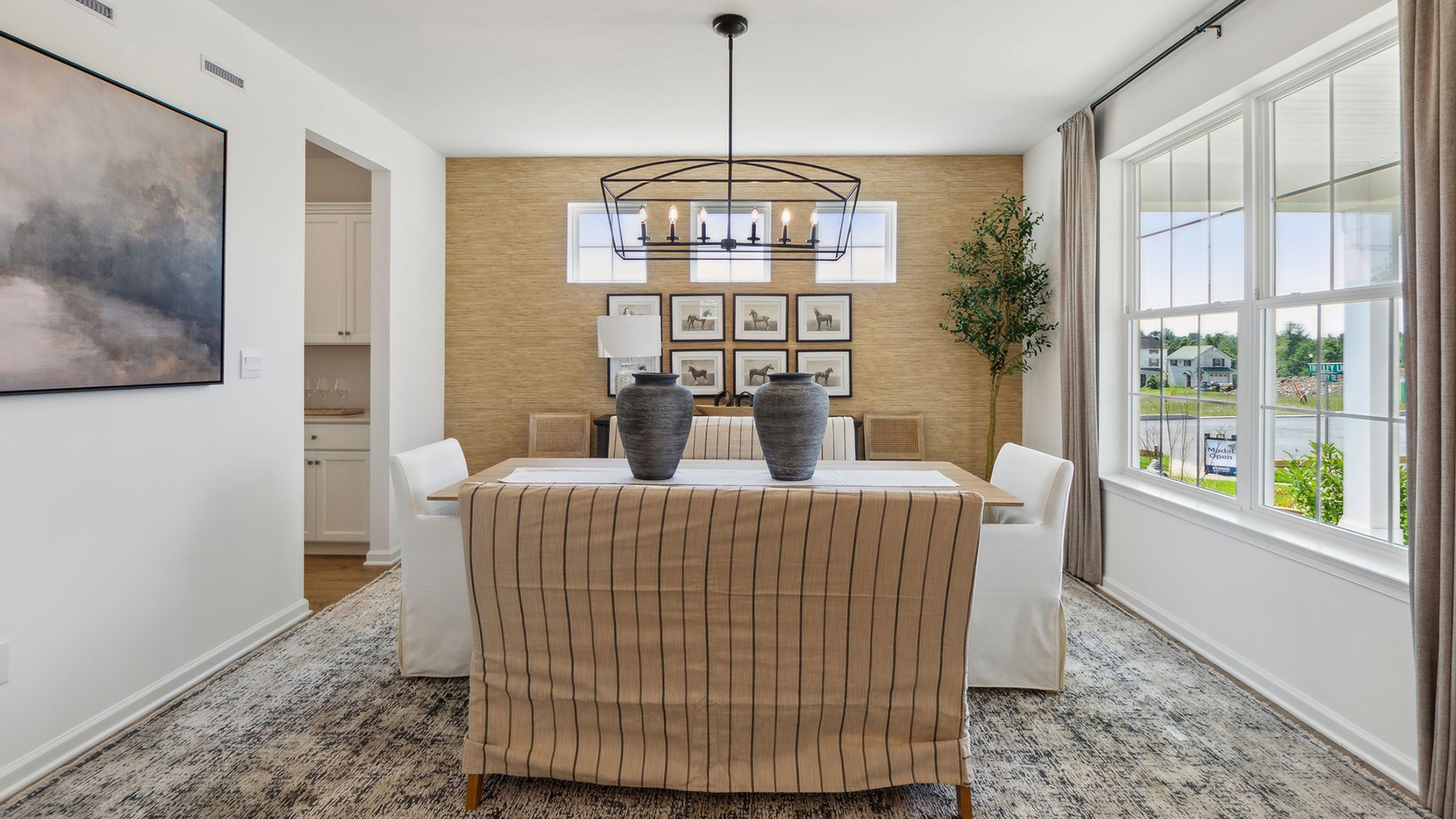 Large dining area with modern chandelier and large double window.