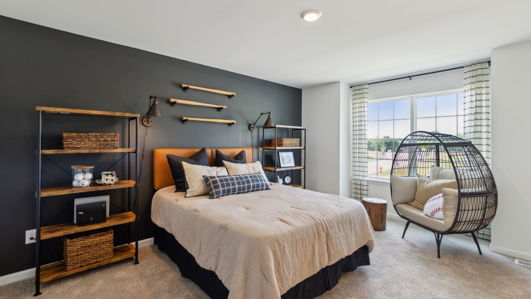 Bedroom with black accent wall and large double window.