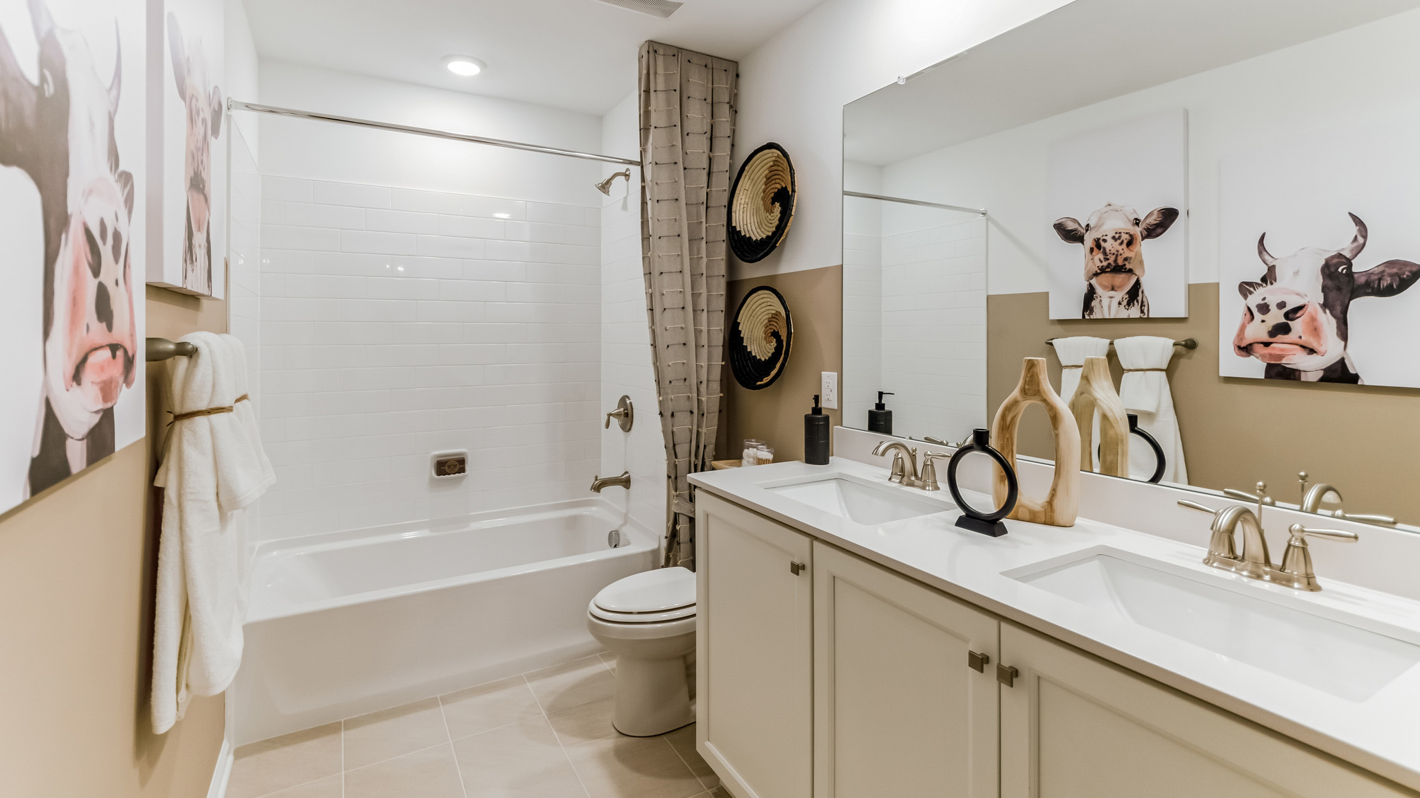 Full bath with a double sink tan vanity.
