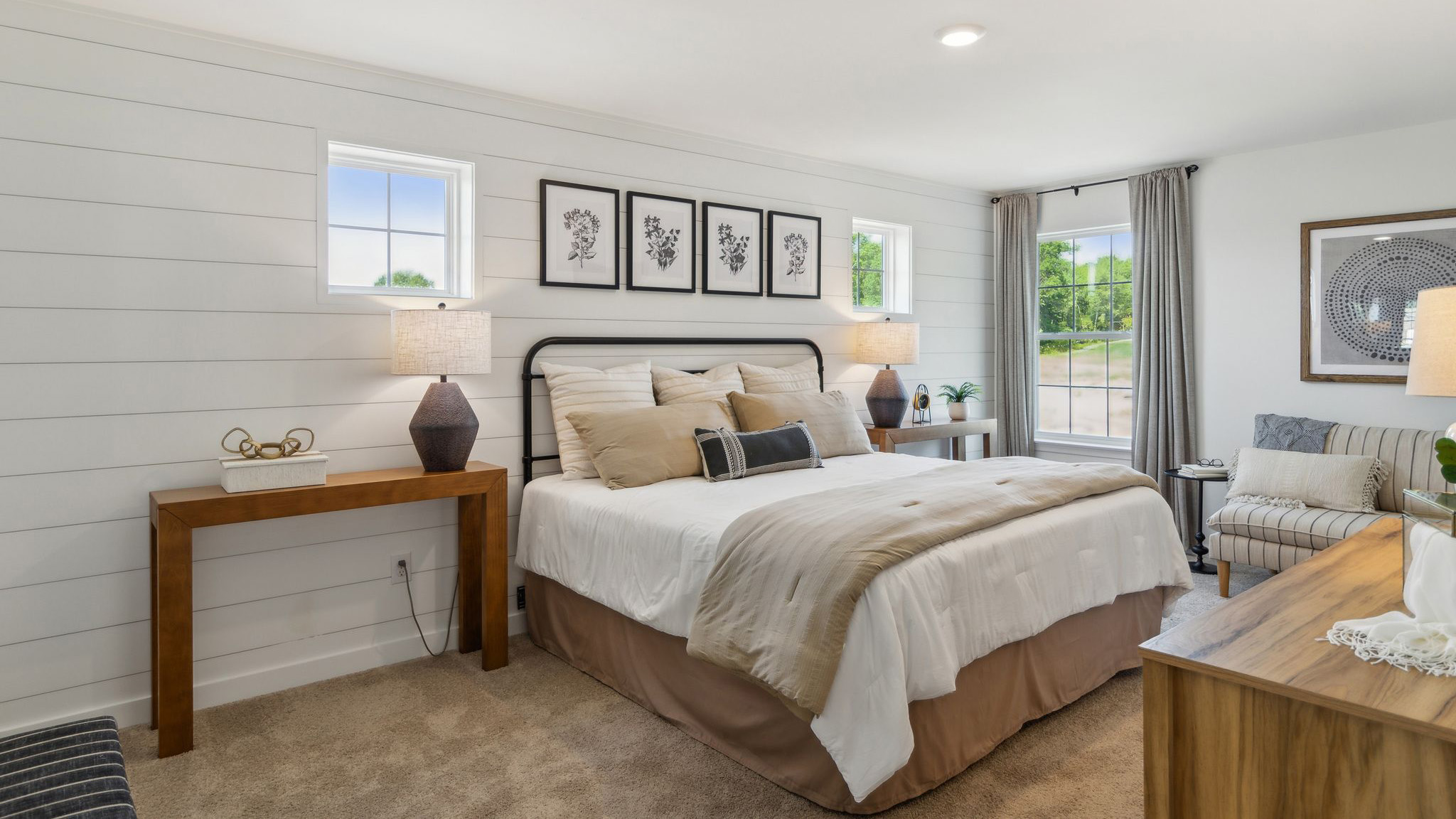 Bedroom with two small high windows on either side of the bed and one large single window to the right.