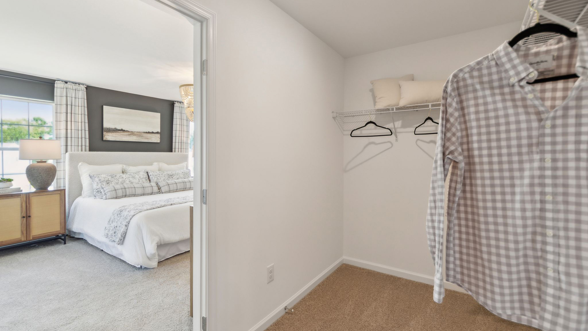Large closet with separate sides connecting to the primary bedroom and laundry room.