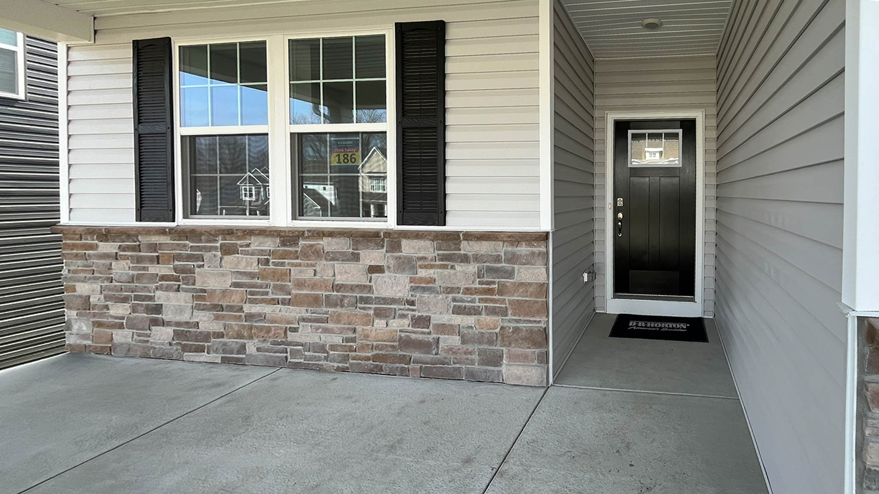 Exterior image of the front porch and a black front door.