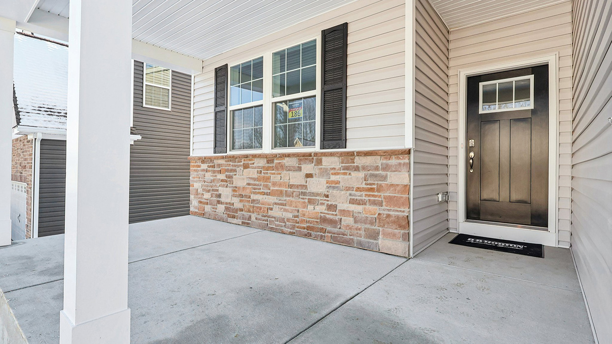 Exterior image of the front porch and a black front door.
