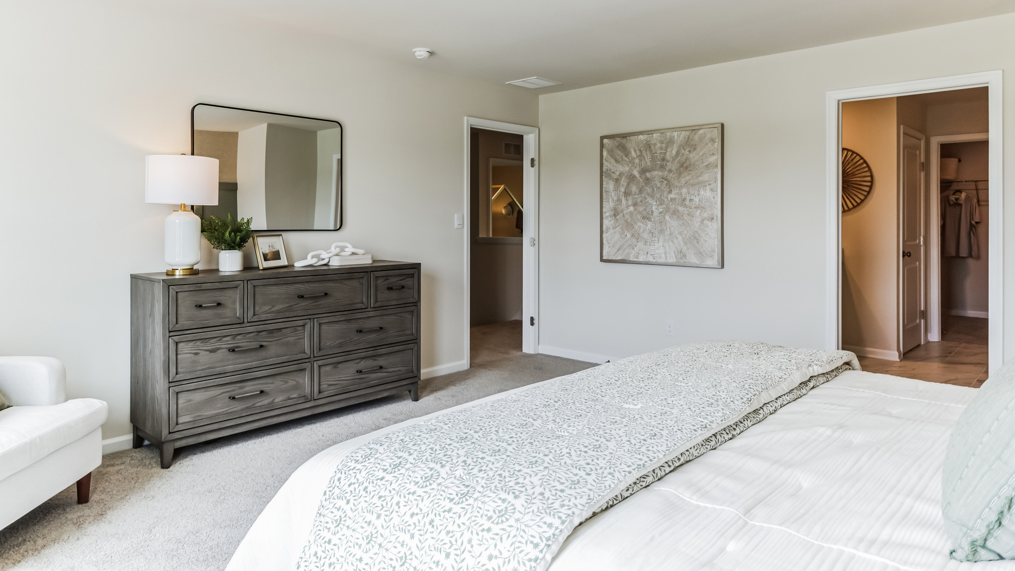 Large bedroom with king bed and entrance door in view.
