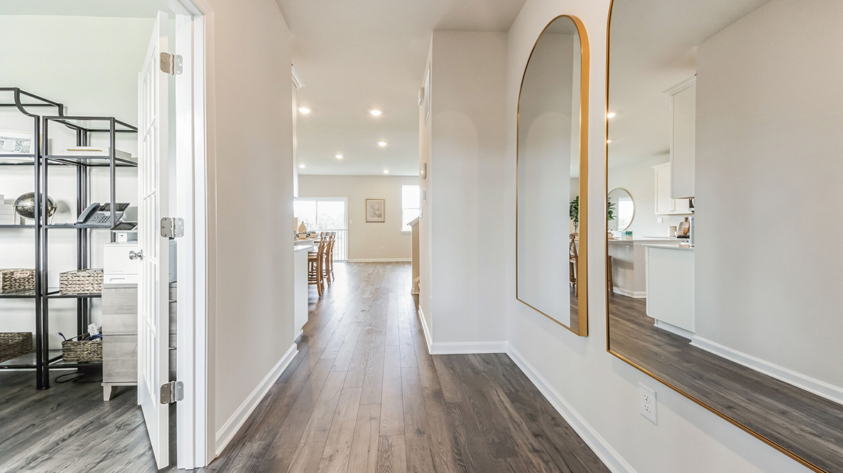 Foyer with potential office room to the left and kitchen and living area ahead.