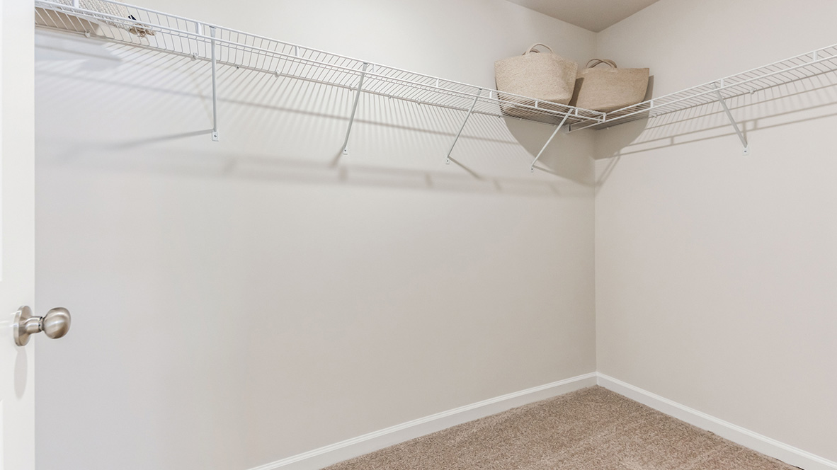 Closet with racks and shelves connecting to the single vanity bathroom.